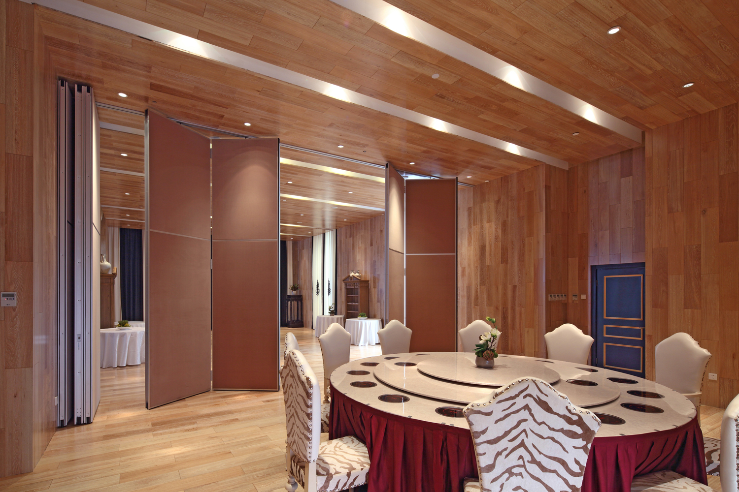 Paired hinged operable partitions folded open beside a banquet table